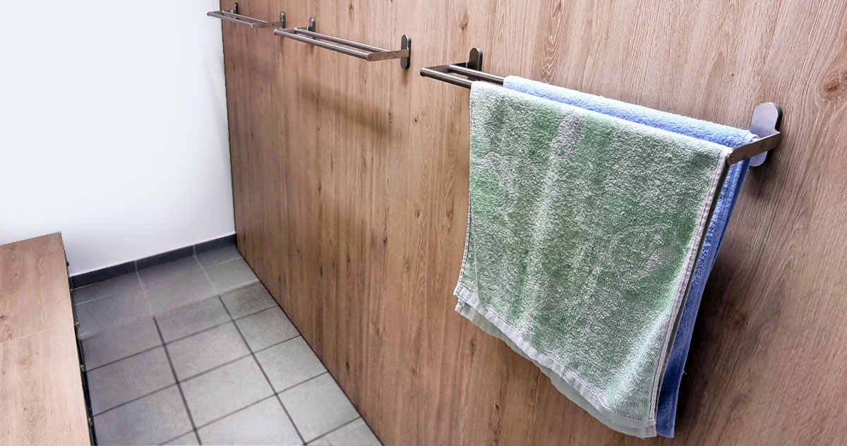 Cover wall of metal garment lockers with towel rails.