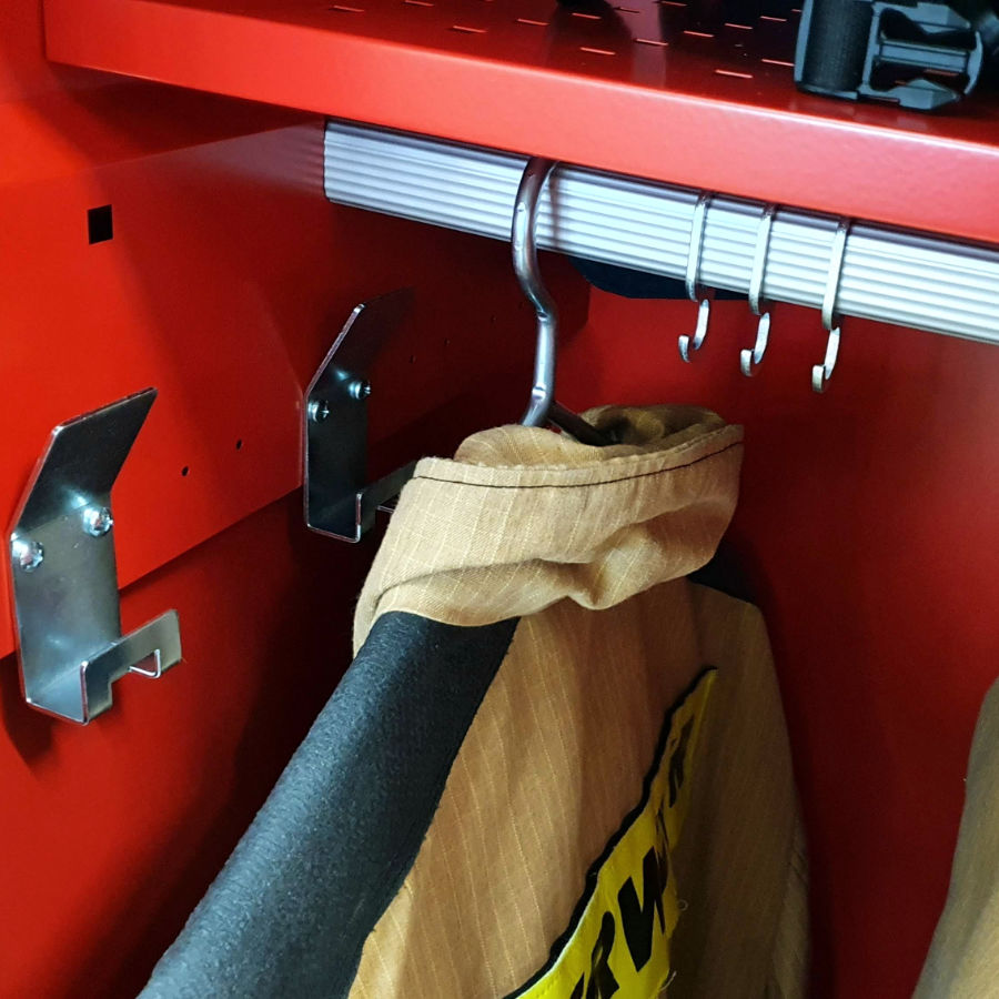 Massive flat oval clothes hanging rail with a firefighter suit on solid metal hangers