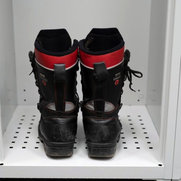 Perforated bottom of the firefighter locker with stored firefighter boots 