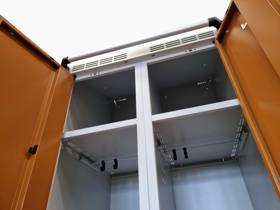 View of the interior layout of a metal wardrobe with storage shelves and hooks for clothes