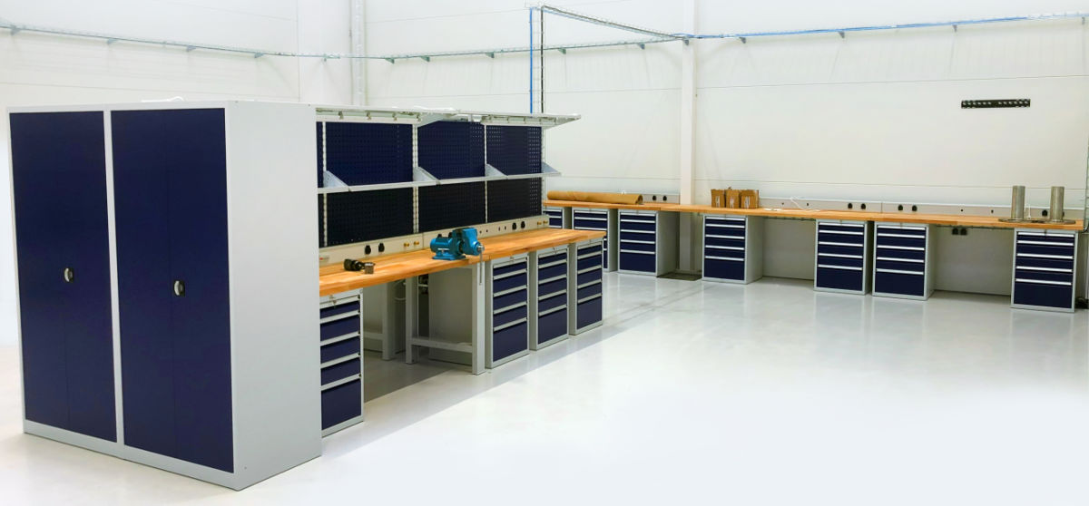 Production plant equipped with workshop workbenches and material storage cabinets